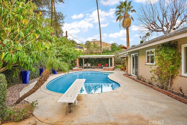 pool with a diving board, a patio area, and a pergola