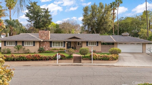 ranch-style home with driveway, a chimney, and an attached garage