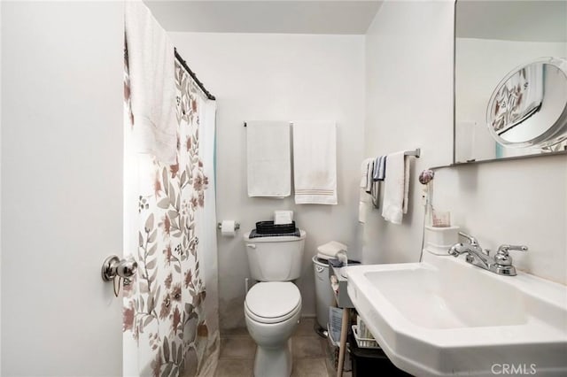 bathroom featuring tile patterned flooring, sink, curtained shower, and toilet