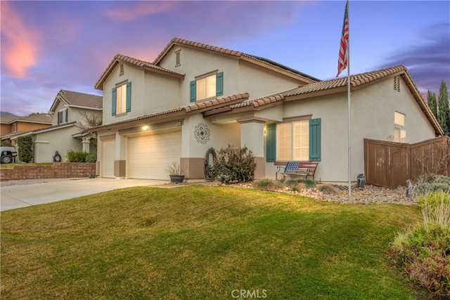 mediterranean / spanish-style house featuring a garage and a lawn