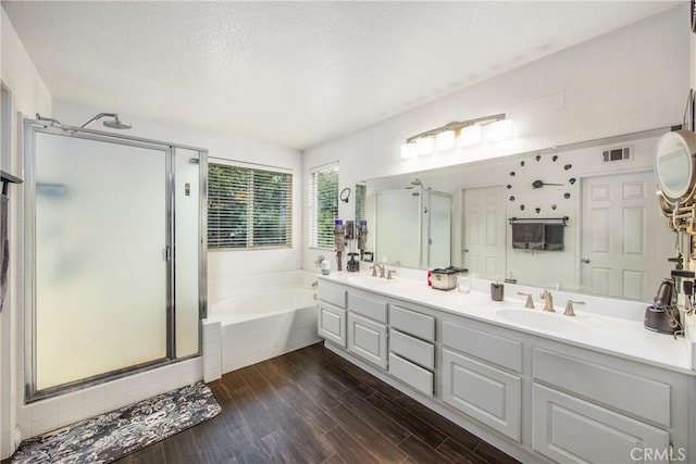 bathroom featuring vanity, separate shower and tub, and hardwood / wood-style floors