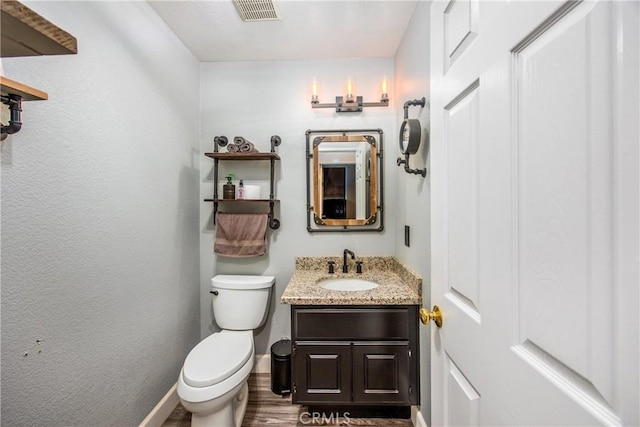 bathroom featuring vanity, hardwood / wood-style flooring, and toilet