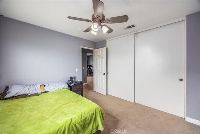 carpeted bedroom featuring a closet and ceiling fan