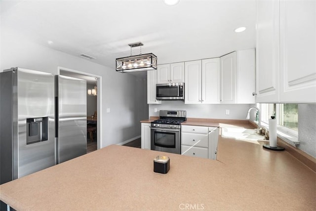 40350 Exa Ely Rd, Hemet, CA 92544 - kitchen with appliances with stainless steel finishes, a sink, white cabinets, light countertops, and a peninsula