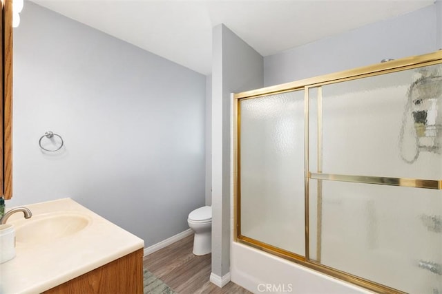 40350 Exa Ely Rd, Hemet, CA 92544 - full bath featuring toilet, wood finished floors, vanity, baseboards, and bath / shower combo with glass door
