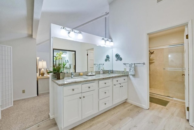 bathroom featuring lofted ceiling, vanity, a shower with door, and hardwood / wood-style floors