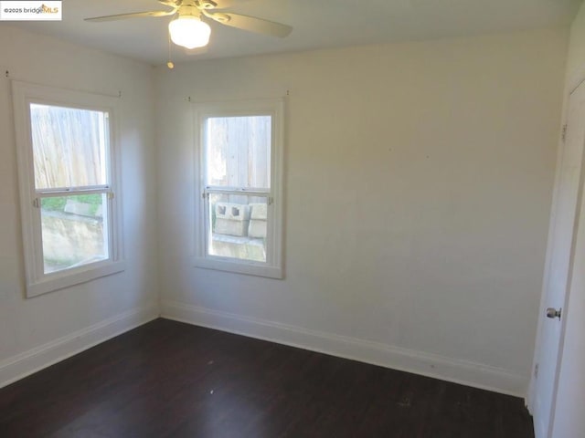 unfurnished room featuring dark wood-type flooring and ceiling fan