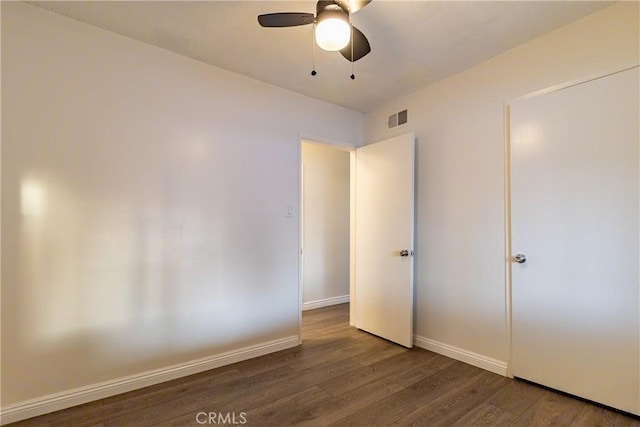 unfurnished bedroom featuring dark wood-type flooring and ceiling fan