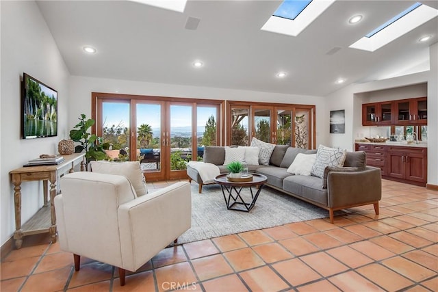 tiled living room with lofted ceiling with skylight