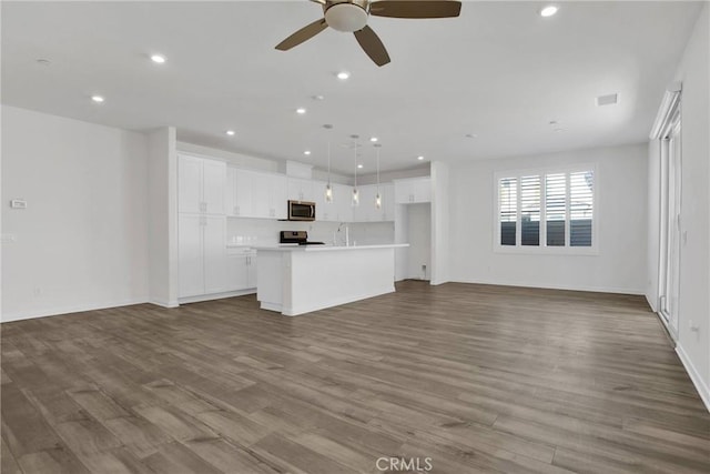 unfurnished living room featuring ceiling fan, sink, and light hardwood / wood-style floors