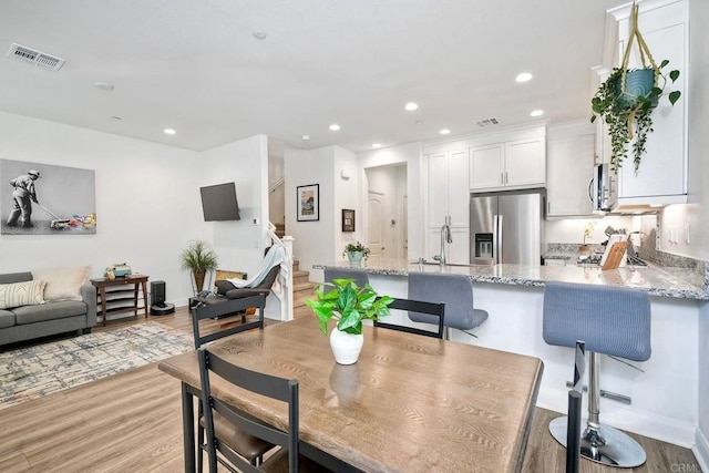 dining space featuring sink and light hardwood / wood-style flooring