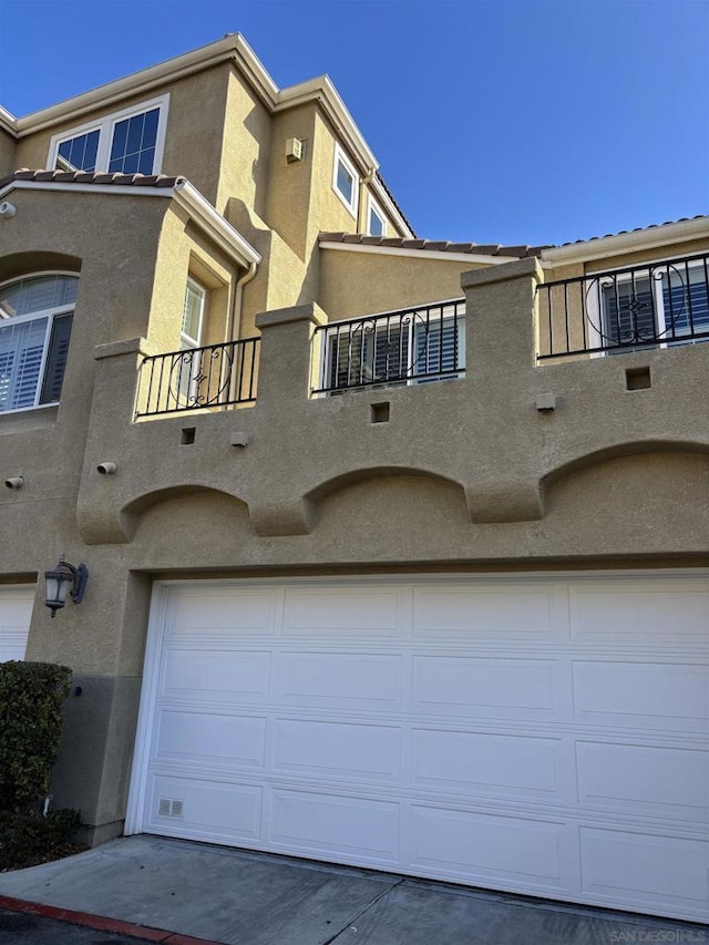 townhome / multi-family property featuring a balcony and a garage