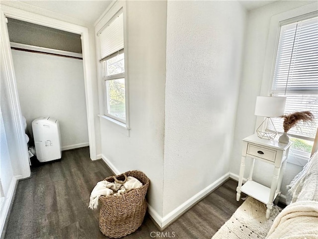 bedroom with a closet, baseboards, and dark wood-style flooring