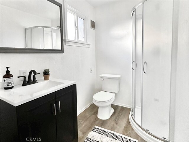 bathroom with vanity, wood-type flooring, an enclosed shower, and toilet