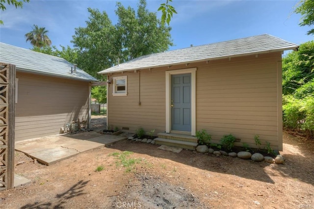 rear view of house with entry steps, crawl space, and a patio