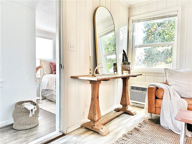 interior details with a wall mounted air conditioner and hardwood / wood-style flooring