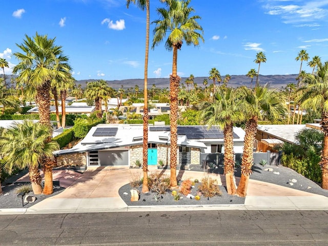 view of front of property featuring a mountain view, a garage, and solar panels