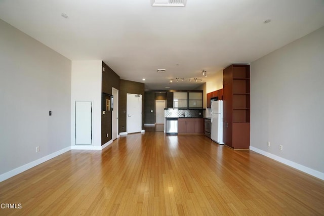 unfurnished living room with rail lighting and light wood-type flooring