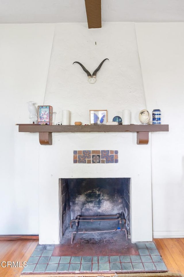 room details featuring hardwood / wood-style flooring, a fireplace, and beamed ceiling