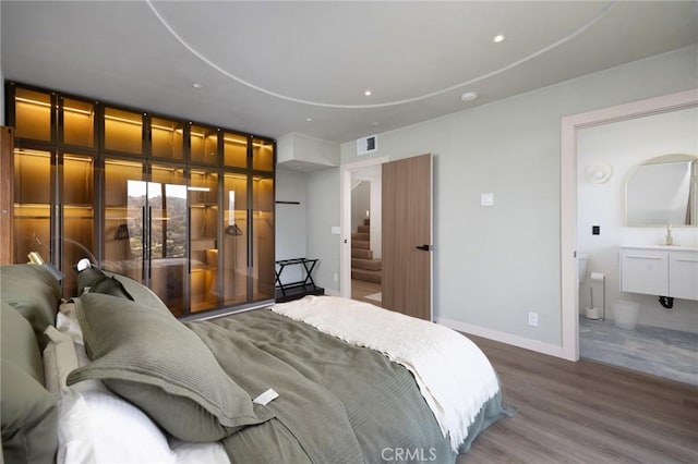 bedroom with recessed lighting, visible vents, a sink, wood finished floors, and baseboards