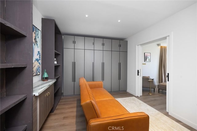 mudroom featuring baseboards, recessed lighting, and light wood-style floors