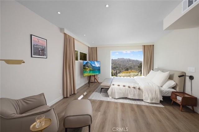 bedroom with recessed lighting, wood finished floors, visible vents, and baseboards