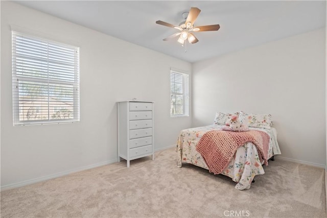 carpeted bedroom with baseboards and a ceiling fan