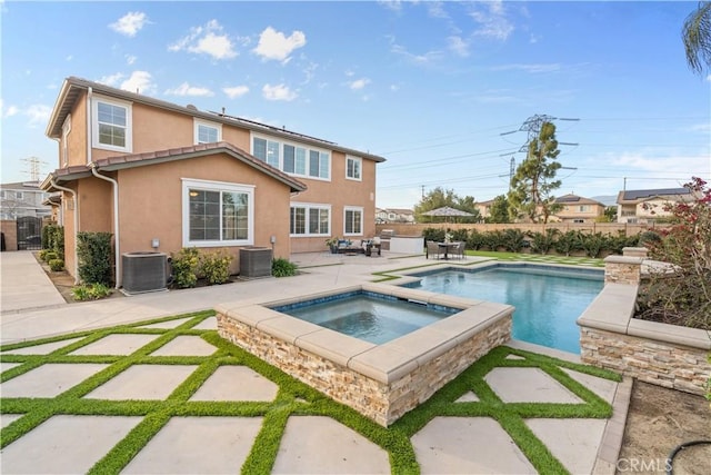 view of swimming pool featuring central AC, a patio, a fenced backyard, and an in ground hot tub