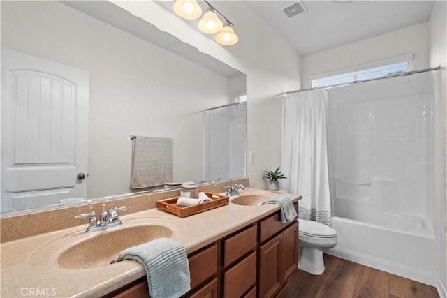 bathroom with toilet, shower / bath combo, a sink, and wood finished floors