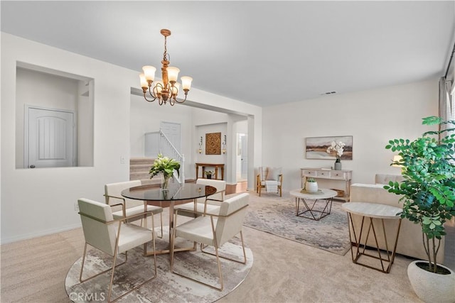 dining room featuring light carpet, baseboards, visible vents, and a notable chandelier