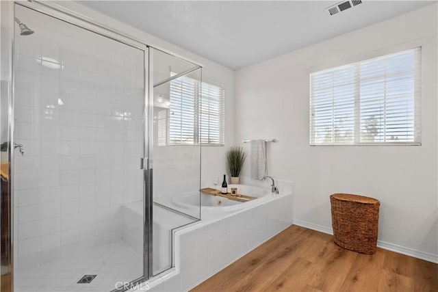 full bath with wood finished floors, a stall shower, a garden tub, and visible vents