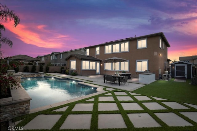 back of house with a patio, stucco siding, a gazebo, an in ground hot tub, and an outdoor structure