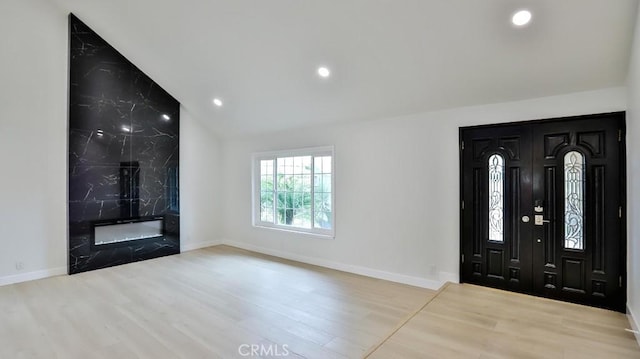 entryway with light wood-type flooring and lofted ceiling