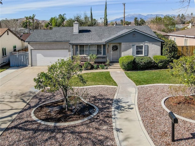 ranch-style house featuring a garage, a mountain view, a front yard, and covered porch