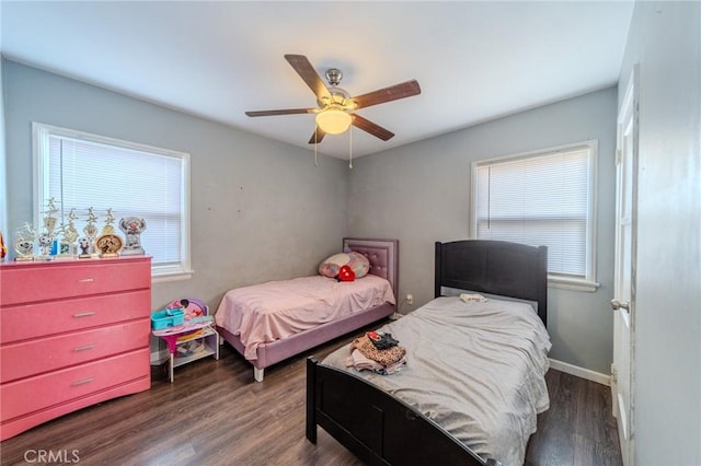 bedroom featuring multiple windows, dark hardwood / wood-style floors, and ceiling fan