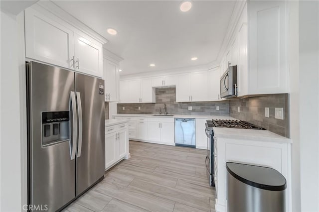 kitchen with white cabinetry, appliances with stainless steel finishes, sink, and tasteful backsplash