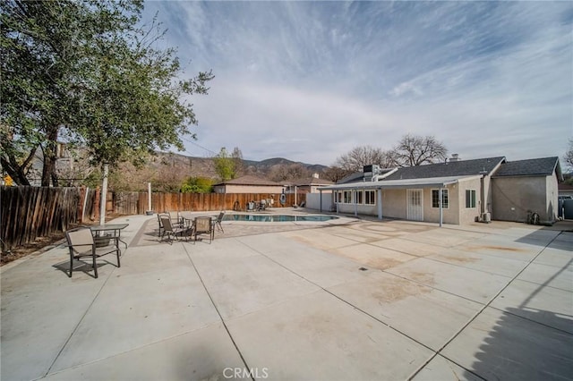 view of patio / terrace with a mountain view and a fenced in pool