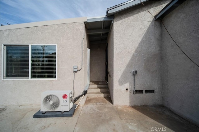 view of exterior entry featuring a patio area and ac unit