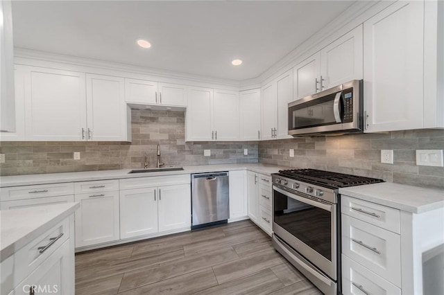 kitchen featuring tasteful backsplash, stainless steel appliances, sink, and white cabinets