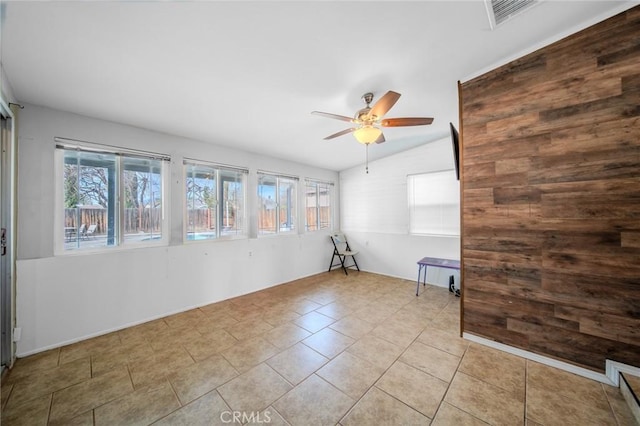 tiled spare room featuring ceiling fan, plenty of natural light, and vaulted ceiling