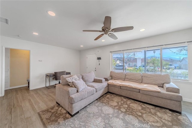 living room featuring light hardwood / wood-style floors and ceiling fan