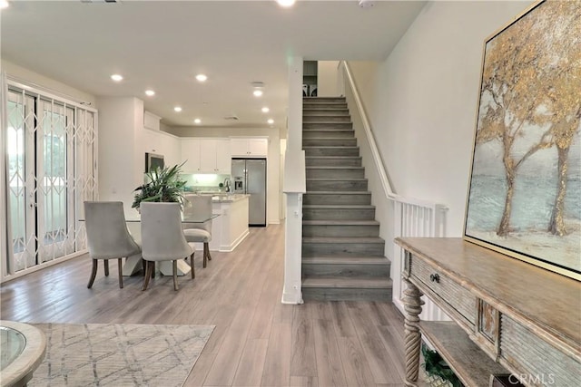 dining area featuring stairs, recessed lighting, and light wood-style floors