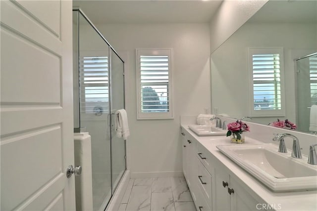 full bath with marble finish floor, a wealth of natural light, and a sink