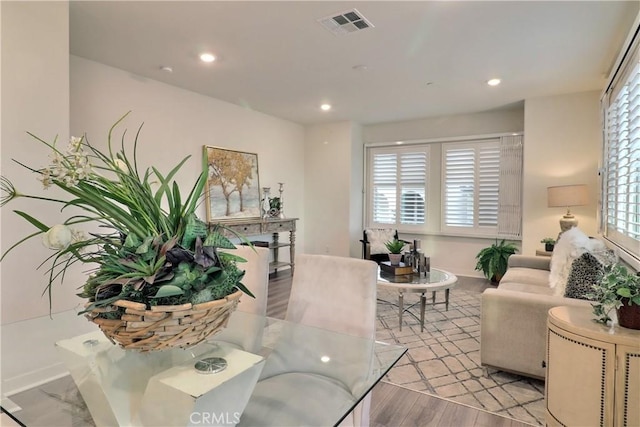 living area featuring baseboards, light wood-style flooring, visible vents, and recessed lighting