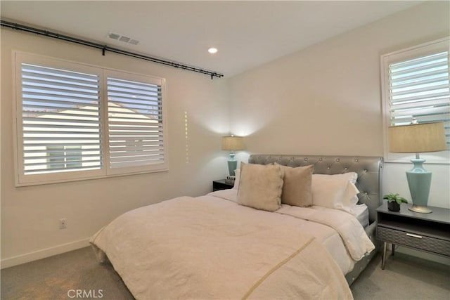 bedroom with carpet, multiple windows, visible vents, and baseboards