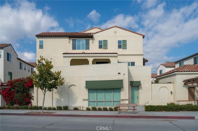 view of front of home with a tile roof and stucco siding