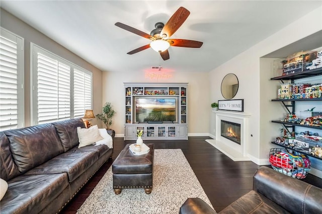 living room featuring dark wood-type flooring and ceiling fan