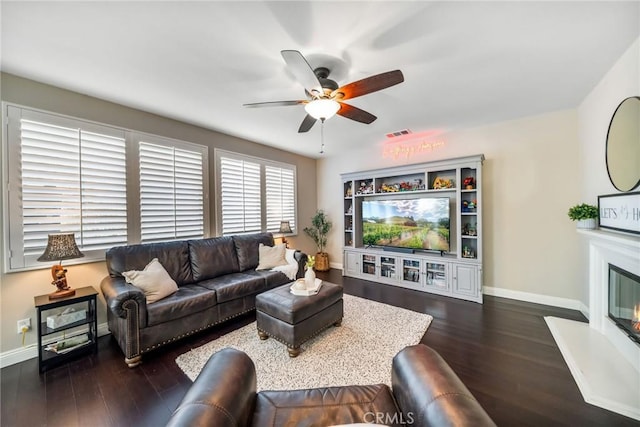 living room with ceiling fan and dark hardwood / wood-style flooring