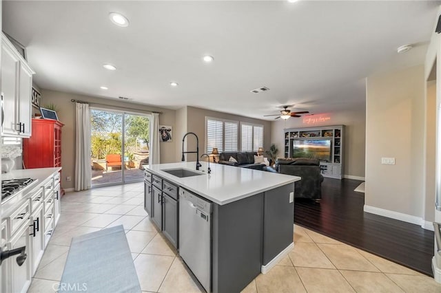 kitchen featuring sink, white cabinetry, a center island with sink, stainless steel appliances, and light tile patterned flooring