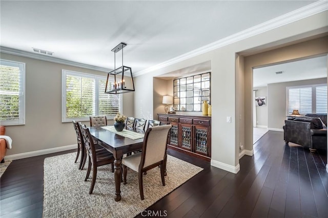 dining space with ornamental molding and dark wood-type flooring